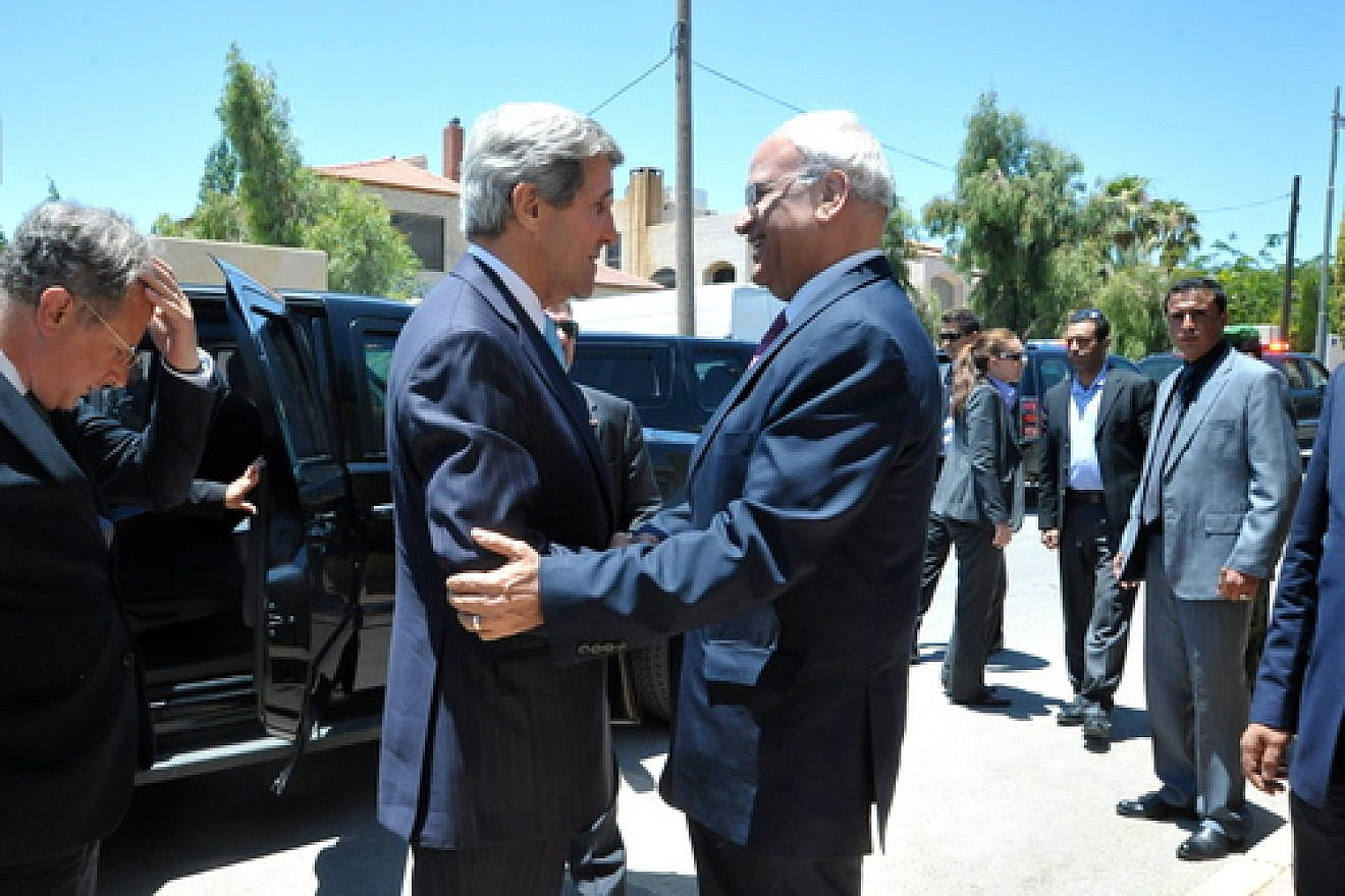 File photo: U.S. Secretary of State John Kerry is greeted by Saeb Erekat, chief negotiator for the Palestinian Authority in the eventually collapsed American-brokered Israel-Palestinian peace talks, before a meeting in Amman, Jordan, on June 28, 2013.