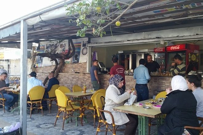 Israeli Jews and Palestinian Arabs eat lunch at a falafel joint in an Arab strip mall in Ariel Credit: Orit Arfa.