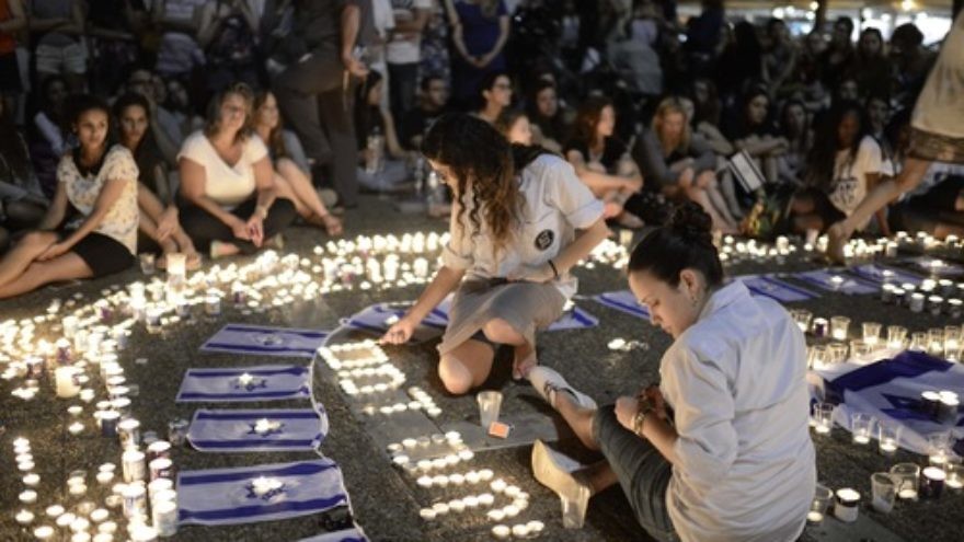 Click photo to download. Caption: Israelis light candles in Tel Aviv's Rabin Square on Monday as they mourn the news of the death of three abducted Jewish teenagers. Israeli forces found the bodies of the three missing teenagers on Monday after a nearly three-week-long search. Credit: Tomer Neuberg/Flash90.