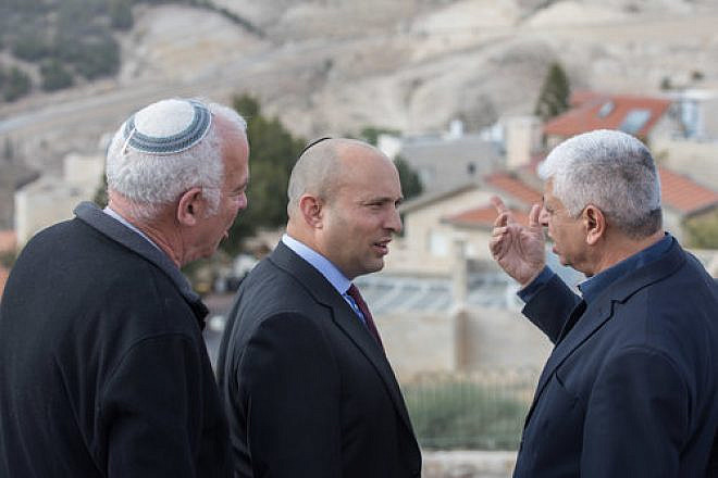Jewish Home Party leader Naftali Bennett (center) speaks with Ma’ale Adumim Mayor Benny Kasriel (right) before the start of a special Jewish Home faction meeting on Jan. 2, 2018. Bennett has advocated for a Knesset bill to be introduced after president-elect Donald Trump takes office on Jan. 20 calling, for Israel’s annexation of Ma’ale Adumim. Credit: Yonatan Sindel/Flash90.