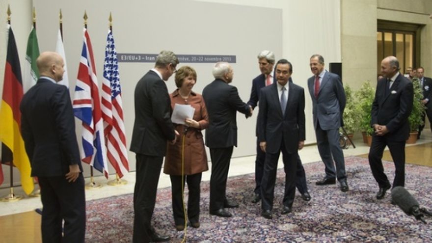 U.S. Secretary of State John Kerry (at center) shakes hands with Iranian Foreign Minister Javad Zarif after the P5+1 powers and Iran concluded negotiations on the Iran nuclear program on Nov. 24, 2013. Credit: U.S. State Department.