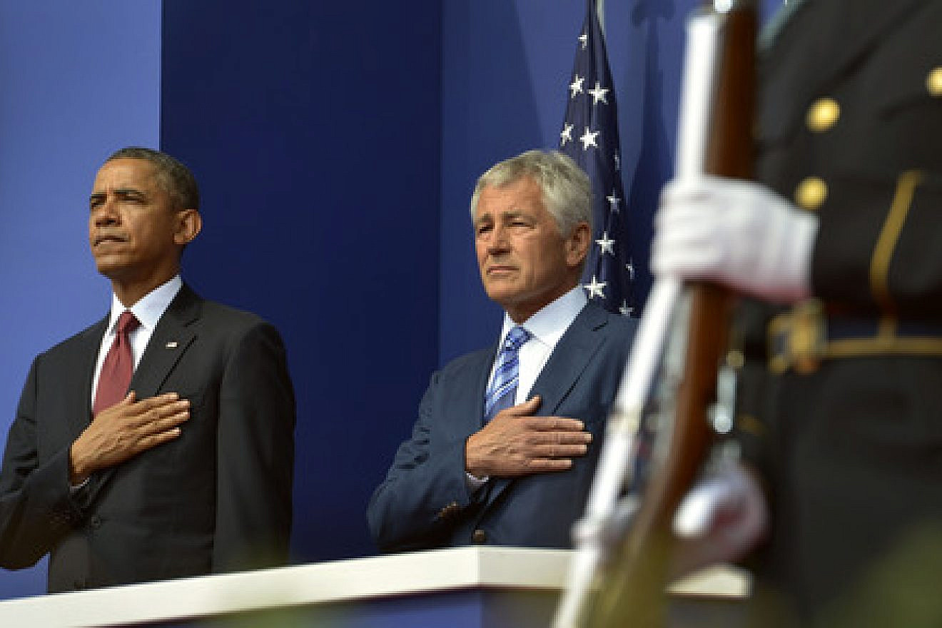President Barack Obama and Secretary of Defense Chuck Hagel place their hands over their hearts as the National Anthem is played in Washington, DC, on July 27, 2013. Obama's selection of Hagel was heavily criticized by the pro-Israel community, and now fresh concerns have arisen over the new appointment of Robert Malley—who had a falling out with the 2008 Obama presidential campaign over his meeting with the terror group Hamas—as a senior director at the National Security Council, where he will manage relations with the Persian Gulf states. Credit: DoD photo by Glenn Fawcett.