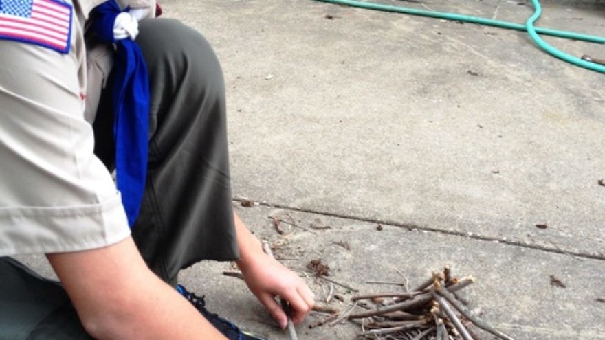 Boy Scout Abraham “Avi” Brudoley makes a bonfire. Pictured is step one: lay the groundwork. Credit: Maayan Jaffe.