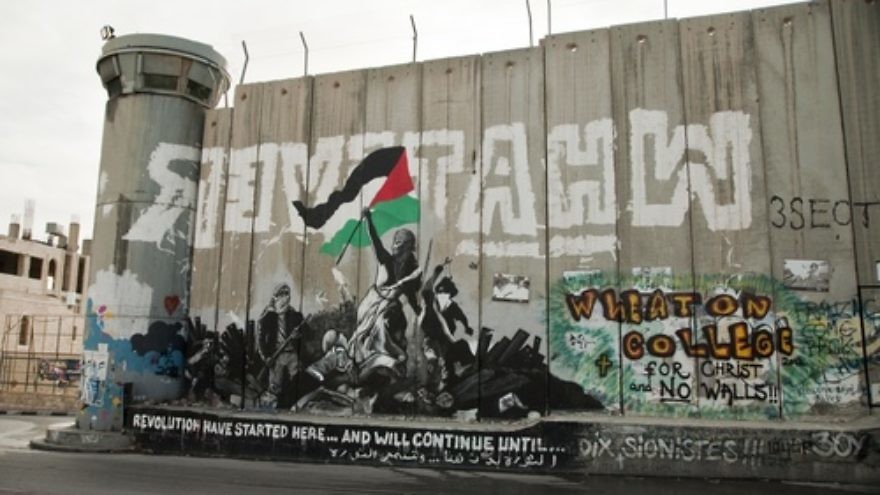 Anti-Israel graffiti on the Israeli security wall in Bethlehem. The wall comes under heavy criticism from those who claim it cuts off Palestinian communities from one another. Credit: Garry Walsh via Wikimedia Commons.