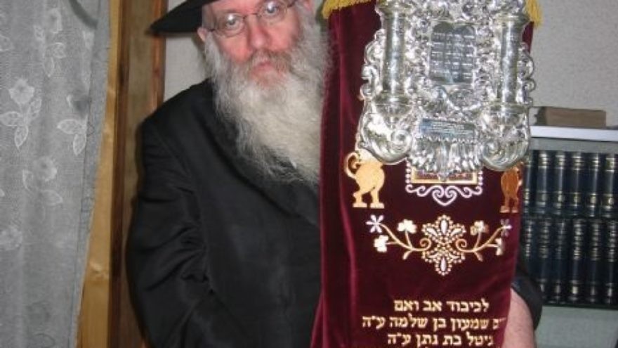 Rabbi Yitzchok Meyer Lipszyc, a Chabad-Lubavitch emissary in Crimea for more than two decades, with a Torah scroll. Credit: Chabad Lubavitch of Crimea.