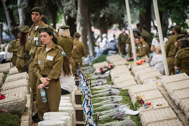 Israeli soldiers stand by the graves of the fallen at the Kiryat Anavim military cemetery on Yom Hazikaron (Memorial Day), on May 1, 2017. Credit: Hadas Parush/Flash90.