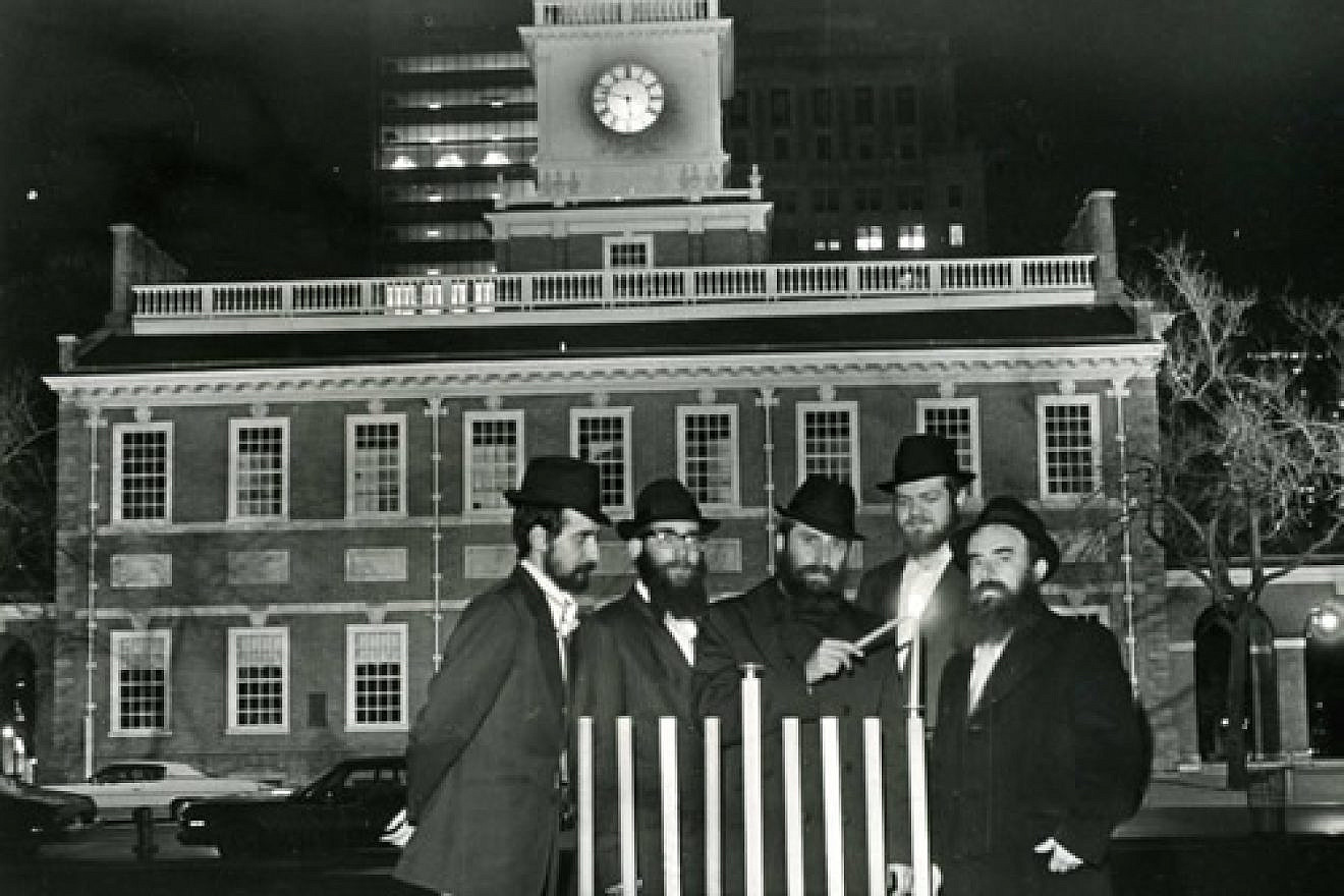 Rabbi Abraham Shemtov, right, in front of Independence Hall in Philadelphia at the lighting of the first-ever public menorah in 1974. With him were yeshivah students who helped build the menorah from scratch. Credit: Lubavitcher Center/Chabad.org.