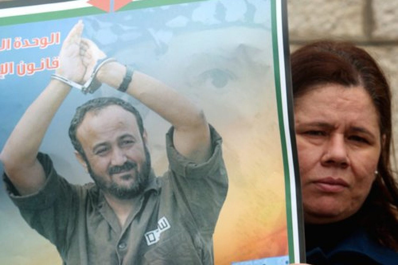 A Palestinian woman holds a portrait of Palestinian terrorist prisoner Marwan Barghouti during a rally in Ramallah, the headquarters of the Palestinian Authority, on March 27, 2012. Credit: Issam Rimawi/Flash90.