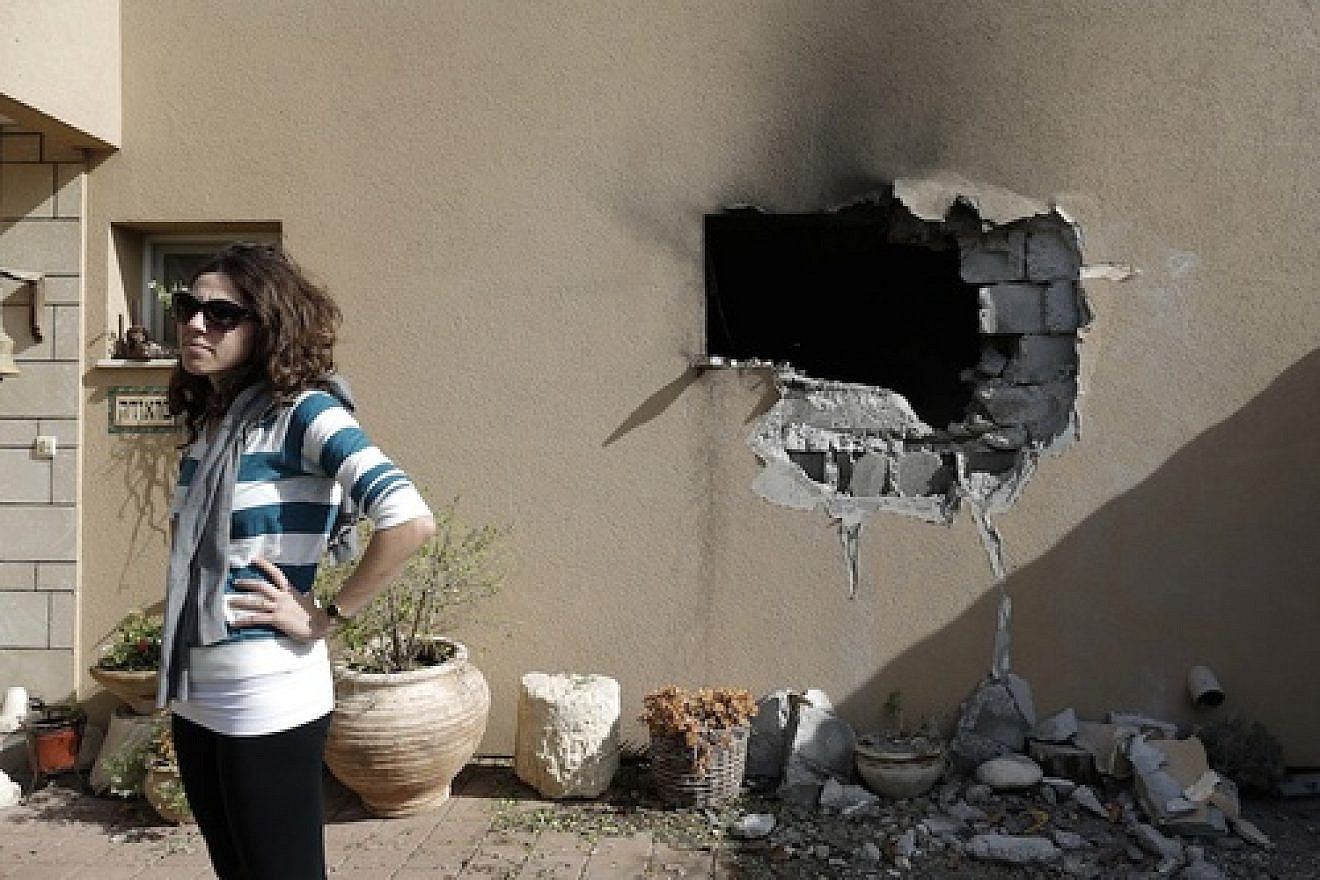 An Israeli woman stands outside a damaged house hit by a rocked fired from the Gaza Strip that hit a house near the Israel-Gaza border, Friday, Nov. 16, 2012. Credit: Tsafrir Abayov/Flash90.