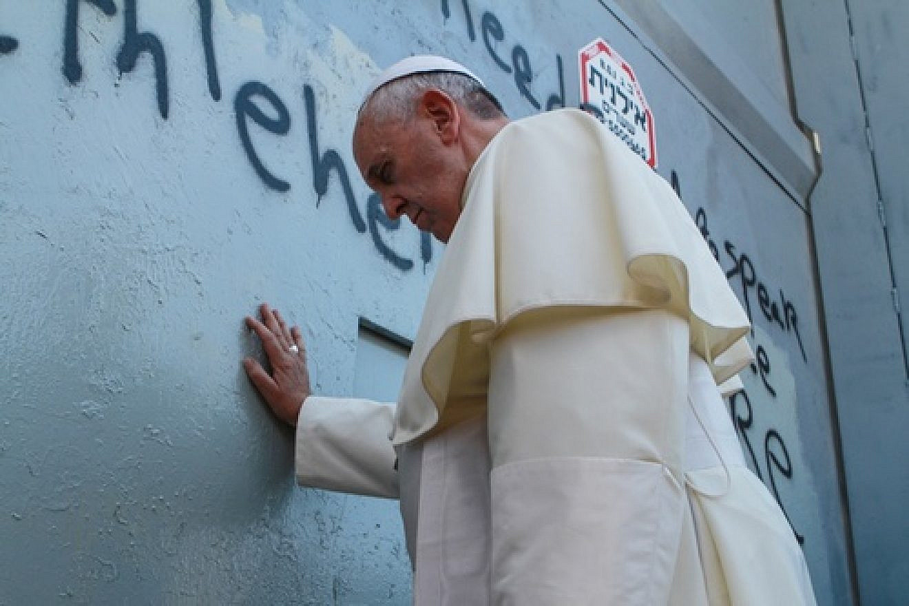 On May 25, 2014, Pope Francis touches the wall that separates Israel from the disputed Palestinian territories on his way to lead a mass in Bethlehem. The pope's stop at the Israeli security fence, which led to a photo op next to anti-Israel graffiti, was unscheduled and ignited a media firestorm. Credit: Nour Shamaly/POOL/Flash90.