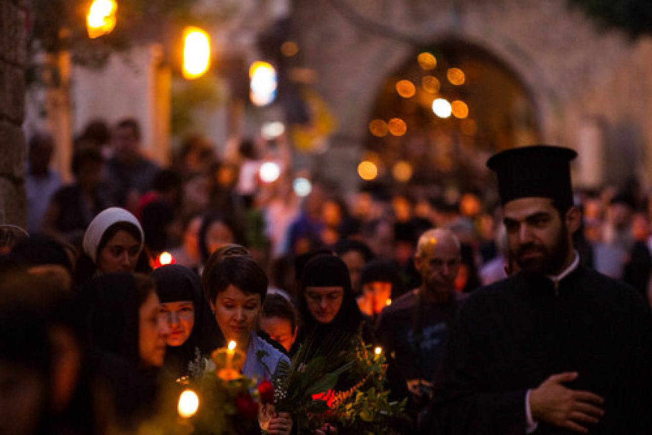 Click photo to download. Caption: Eastern Orthodox Christian nuns hold candles and flowers as they walk along the Via Dolorosa in the Old City of Jerusalem on Aug. 25, 2015. Credit: Micah Bond/Flash90.