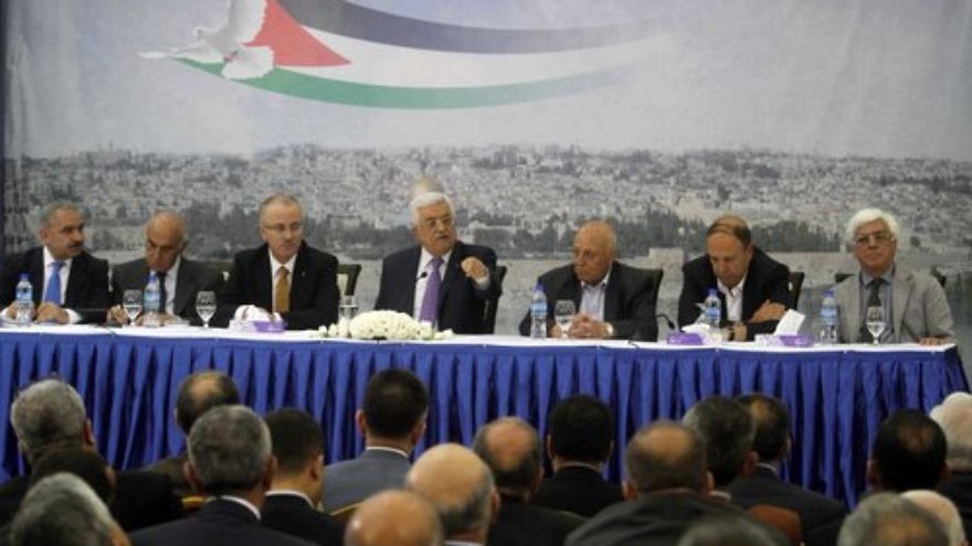 Palestinian Authority leader Mahmoud Abbas (center) attends a meeting of Palestinian businessmen in Ramallah April 29, 2014. The Palestinian National Fund, often in partnership with the P.A., pays salaries to imprisoned Palestinian terrorists and their families. Credit: Issam Rimawi/Flash90.