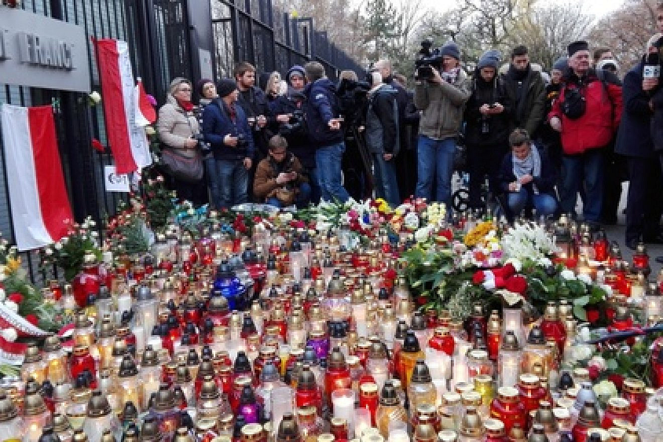 Candles and flowers for the victims of the Nov. 13 Paris attacks outside of the French Embassy in Warsaw. Credit: Halibutt via Wikimedia Commons.