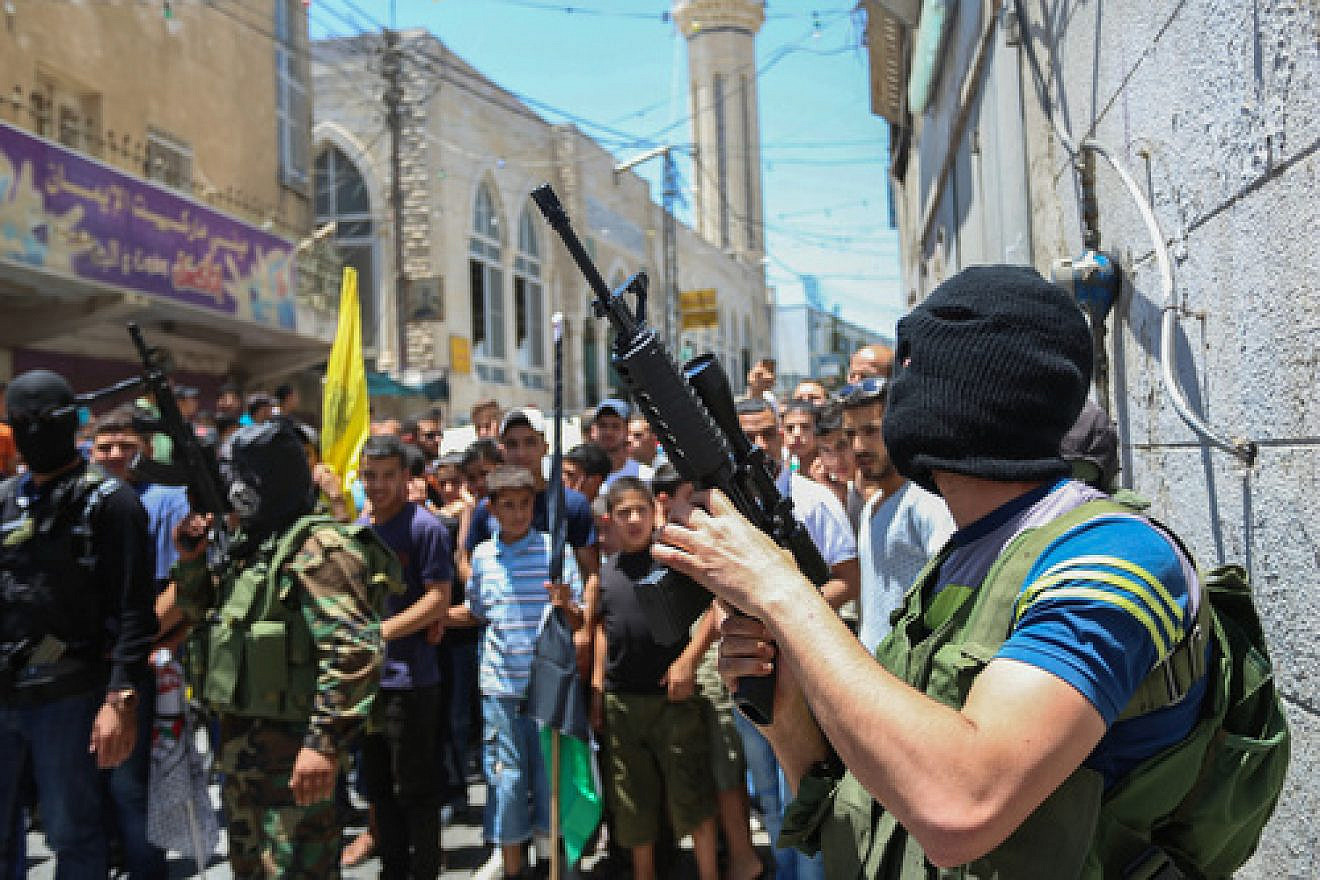 Click photo to download. Caption: A crowd of Palestinians, including some who are armed and masked, in the Qalandiya refugee camp on July 3, 2015. Credit: Flash90.