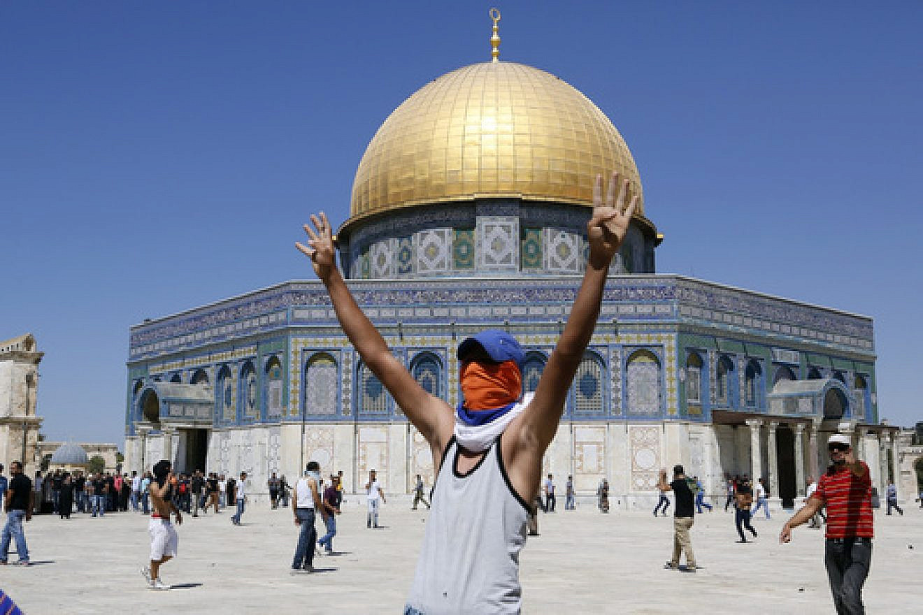 A Palestinian rioter raises his hands in a "V" for "victory" near the Dome of the Rock on the Temple Mount in Jerusalem. Photo by Sliman Khader/Flash90.