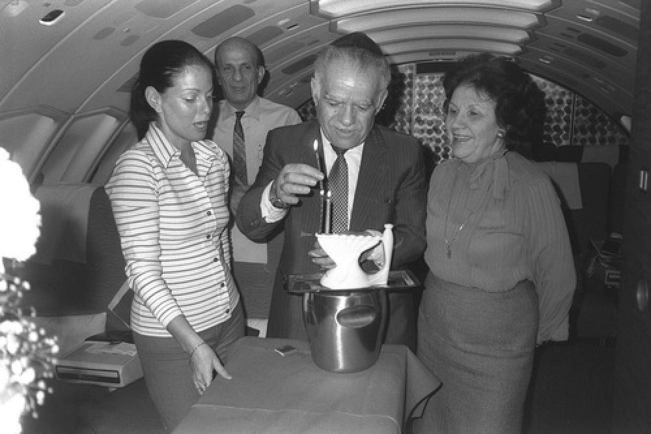 Former Israeli Prime Minister Yitzhak Shamir flanked by his wife, Shulamit, and a hostess lighting Hanukkah candles on their return flight from Washington, on Feb. 12,1983. Credit: GPO.