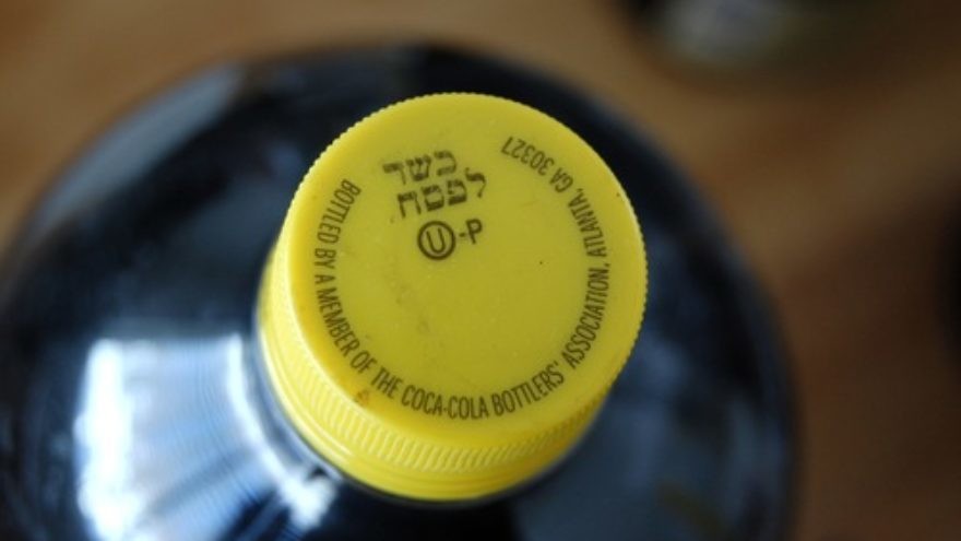 A kosher-for-Passover bottle of Coca-Cola, distinguished from ordinary Coca-Cola bottles by its yellow cap and special "hechsher." Credit: Mark H. Anbinder via Flickr.com.