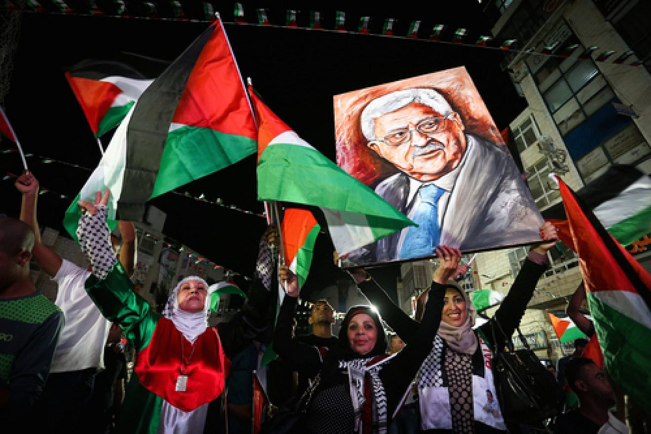 Palestinians in Ramallah wave their national flags and a picture of Palestinian Authority leader Mahmoud Abbas while they watch a live-screening of Abbas's speech at the United Nations on Sept. 30, 2015. Photo by Flash90.