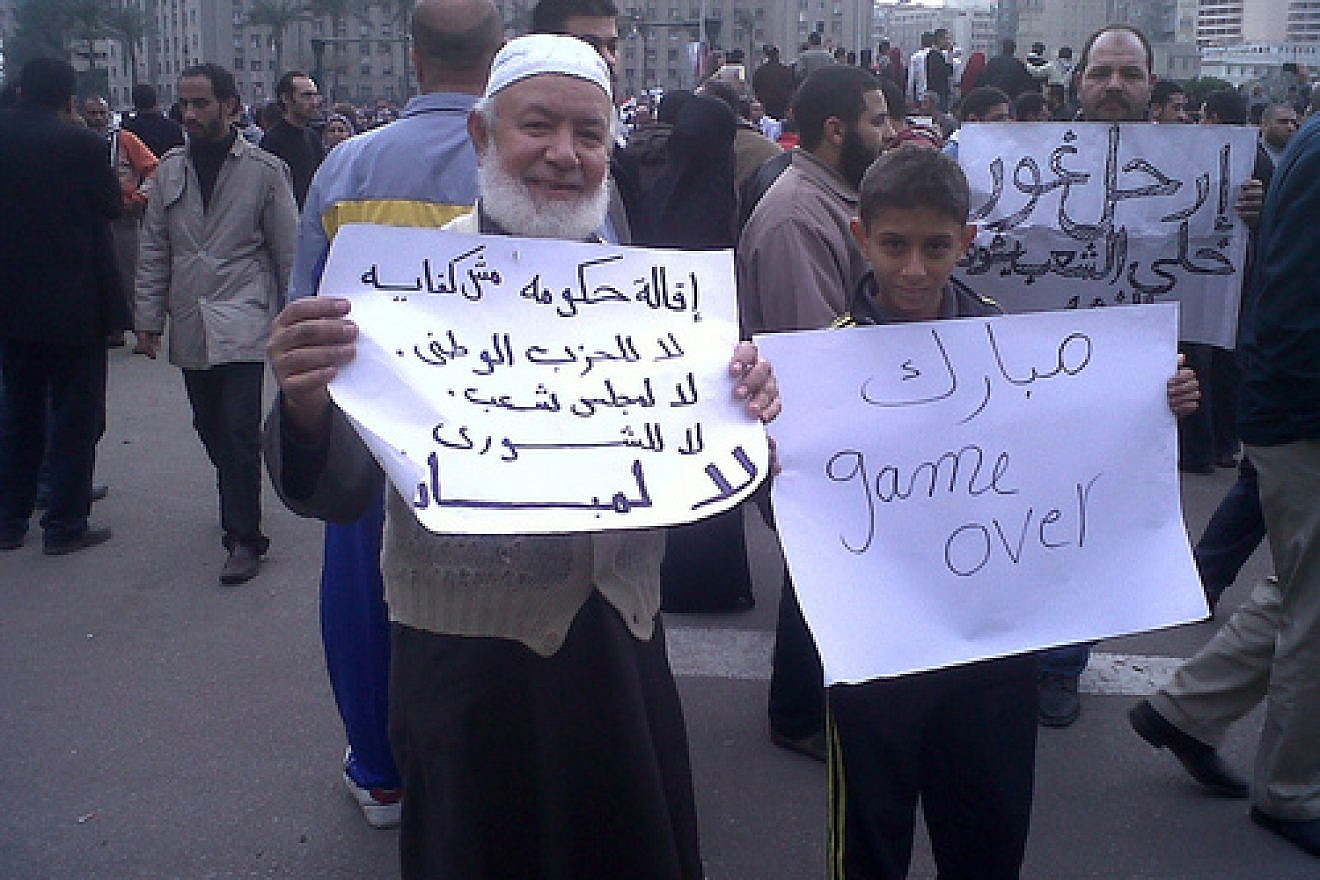 Click photo to download. Caption: (From left to right) In Egypt on Jan. 30, 2011, one protester's sign reads "The stepping down of the government is not enough.. No to the NDP, No to the MPs.. No to Mubarak," and the other's reads "Mubarak Game Over." Credit: BanyanTree.