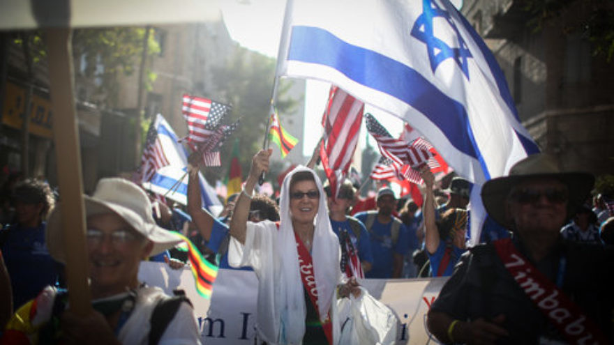 During the Jewish holiday of Sukkot, thousands of evangelical Christians wave Israeli, American and other national flags as they march in a Jerusalem parade as part of the International Christian Embassy Jerusalem’s (ICEJ) Feast of Tabernacles festivities. Credit: Hadas Parush/Flash90.