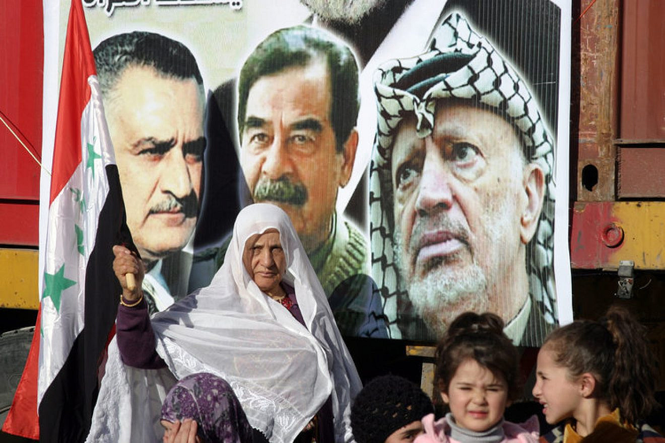 Palestinians commemorate the third anniversary of the death of Saddam Hussein during a rally in the town of Halhoul near Hebron on Jan. 15, 2010. Next to the picture of Hussein (center) is a photo of late Palestinian leader Yasser Arafat. Credit: Najeh Hashlamoun/Flash90.