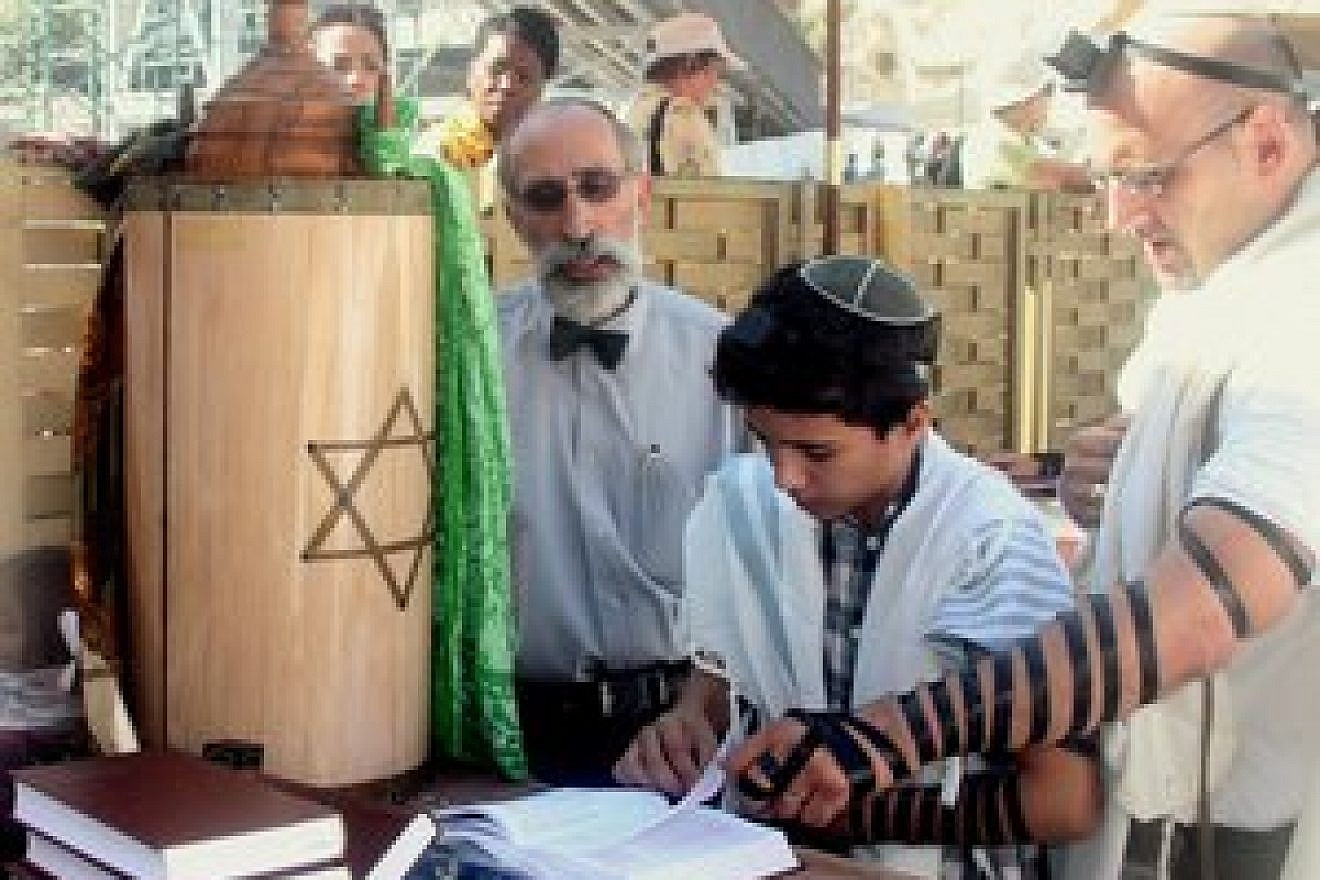 A bar mitzvah boy reads his Torah portion at the Western Wall. Credit: Peter van der Sluijs/Wikimedia Commons.