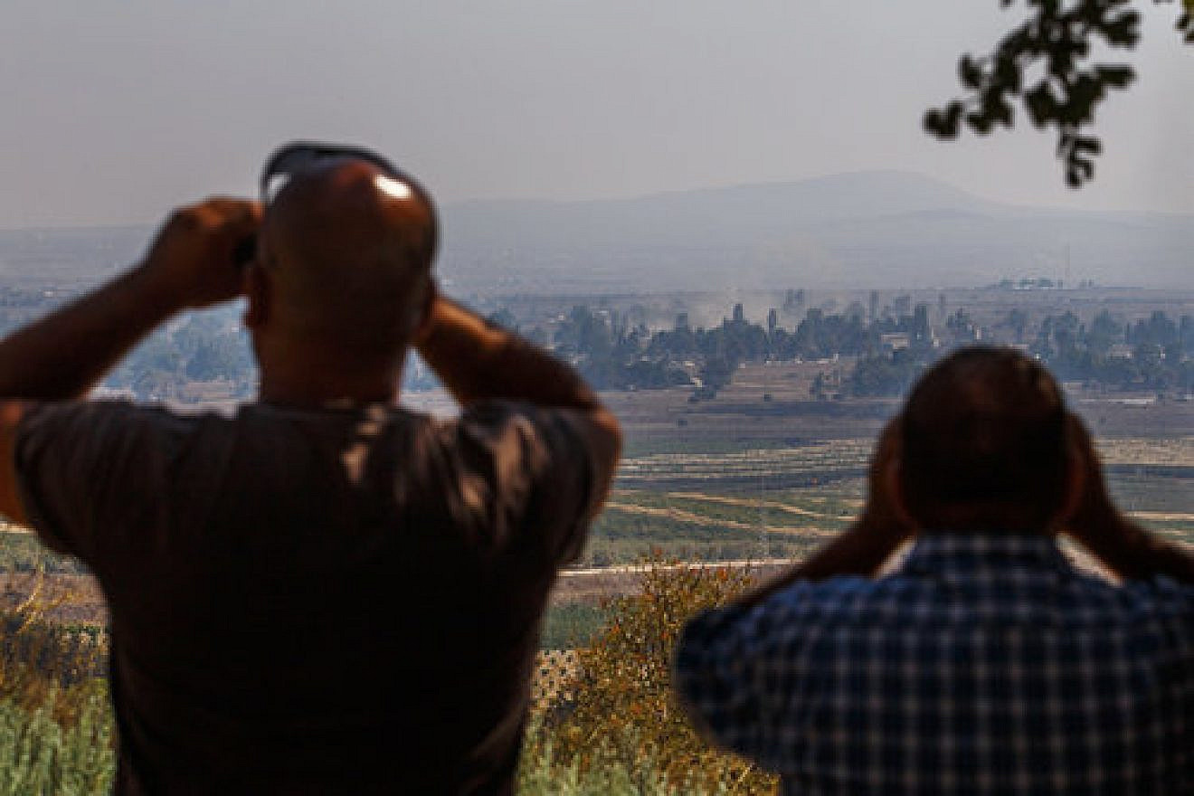 Israelis in the northern Golan Heights region watch smoke rise in Syria in September 2014. Credit: Flash90.