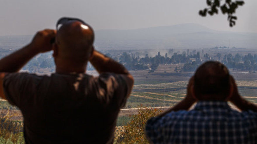 Israelis in the northern Golan Heights region watch smoke rise in Syria in September 2014. Credit: Flash90.