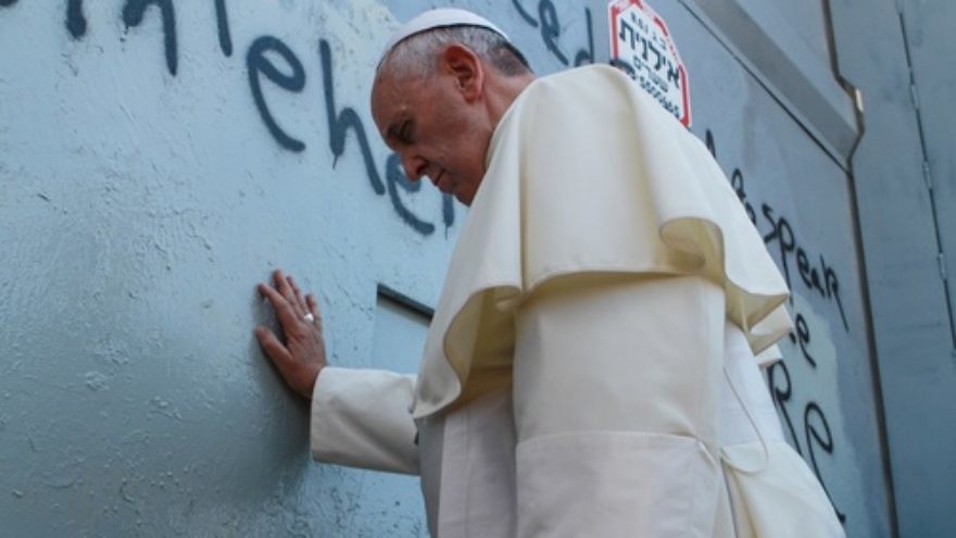 Pope Francis touches the Israeli security barrier on his way to lead a mass in Bethlehem, on May 25, 2014. Credit: Nour Shamaly/POOL/Flash90.