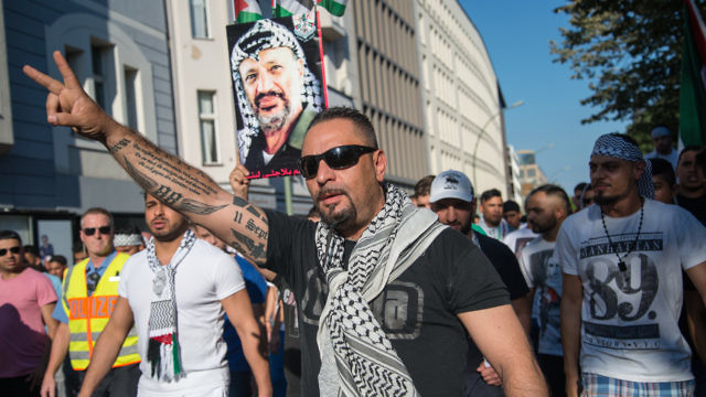 In July 2014 in Berlin, demonstrators carry a picture of late Palestinian leader Yasser Arafat and protest against the Israeli military's Operation Protective Edge in Gaza. Credit: Boris Niehaus via Wikimedia Commons.