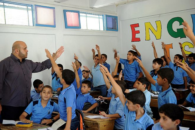 Palestinian boys raise their hands at a school in the Gaza Strip supported by the United Nations Relief and Works Agency for Palestine Refugees in the Near East (UNRWA) in September 2011. Credit: U.N. Photo/Shareef Sarhan.
