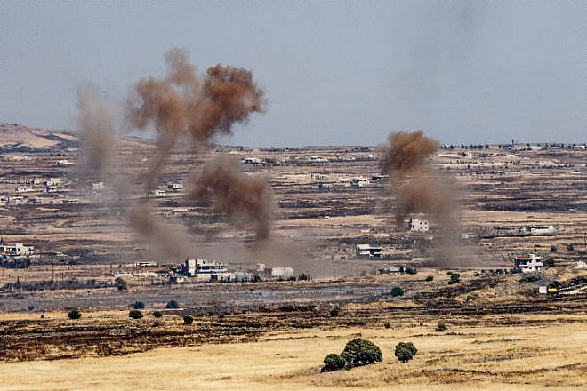 A picture taken from the Israeli side depicts smoke rising near the Israeli-Syrian border in the Golan Heights during fights between the rebels and the Syrian army, June 25, 2017. Photo by Basel Awidat/Flash90.