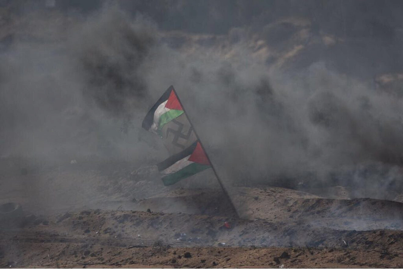 Palestinians display a flag with a swastika in the middle during Gaza border protests in April 2018. Credit: IDF via Twitter.