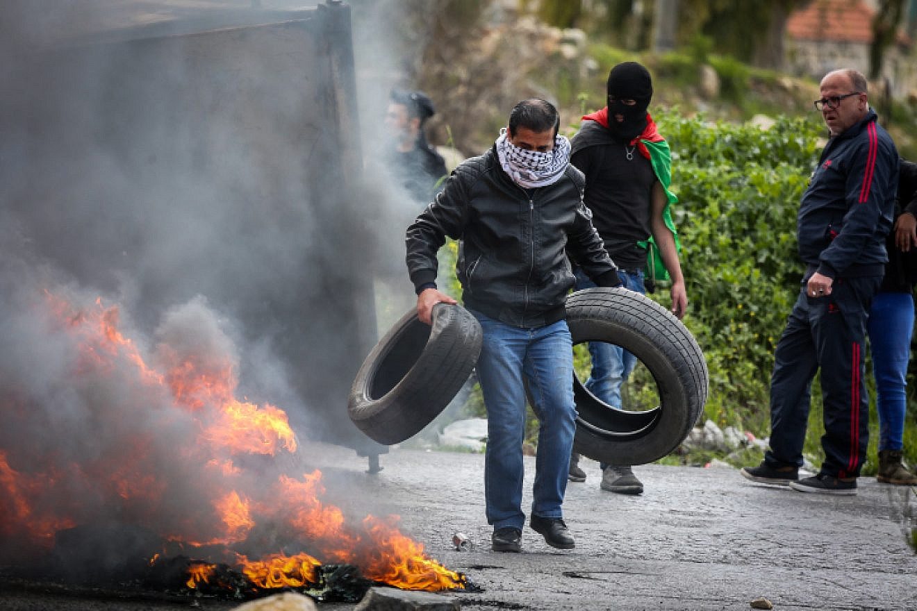 Palestinian protesters burn tires near Ramallah in the West Bank during a protest against U.S. President Donald Trump's decision to recognize Jerusalem as the capital of Israel, March 16, 2018. Photo by Flash90.