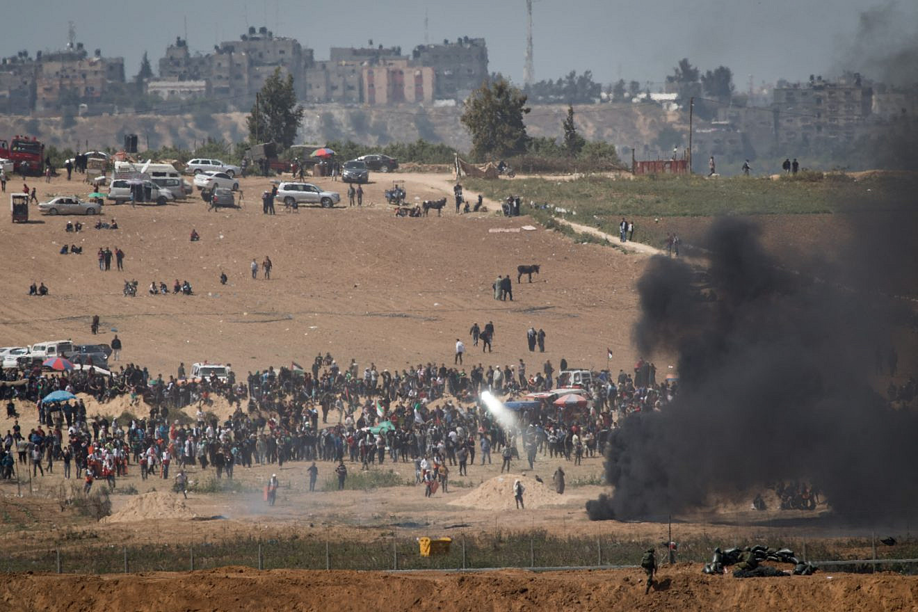 Palestinian protesters attempt to blind Israel Defense Forces with mirrors, as they demonstrate and burn tires near the border with Israel in the Gaza Strip, as seen from the Israeli side of the border on April 6, 2018. Credit: Hadas Parush/Flash90