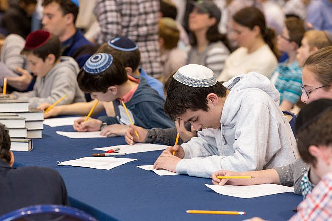 Students write feverishly at Chidon HaTanakh at Manhattan Day School. Photo by David Khabinsky.