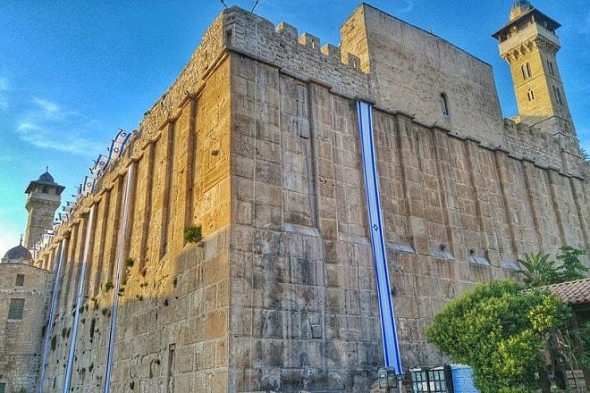 Israel flags decorate the 2,000-year-old Cave of the Patriarchs complex in Hebron in anticipation of Israel's Independence Day. The same Herodian masonry is used for the Western Wall in Jerusalem. Photo by Yishai Fleisher.