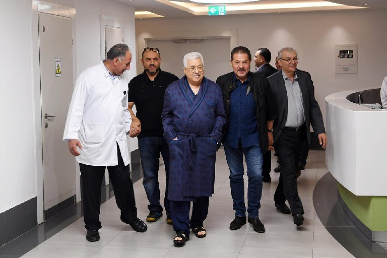 Palestinian Authority leader Mahmoud Abbas (center, in robe) in the hospital in Ramallah. The two men flanking him are his sons. Source: Arab Press/JCPA.