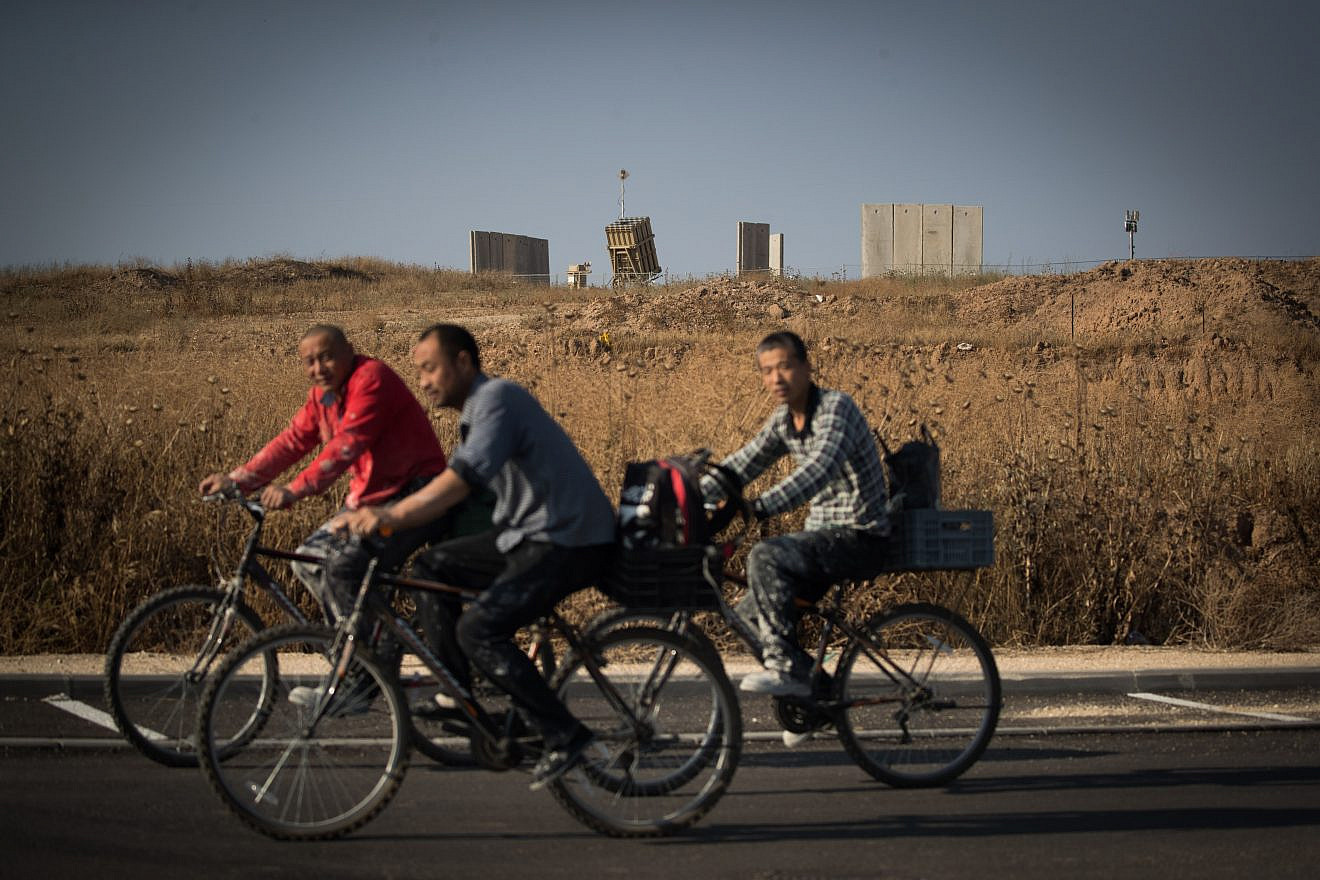 People ride bicycles near an Iron Dome anti-missile battery near the city of Sderot in southern Israel, May 29, 2018. Credit: Yonatan Sindel/Flash90