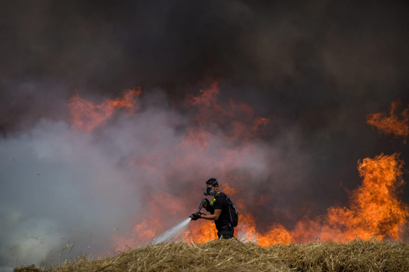 Israeli firefighters extinguish flames in a wheat field caused from kites flown by Palestinian protesters near the Gaza border on May 30, 2018. Photo by Yonatan Sindel/Flash90.