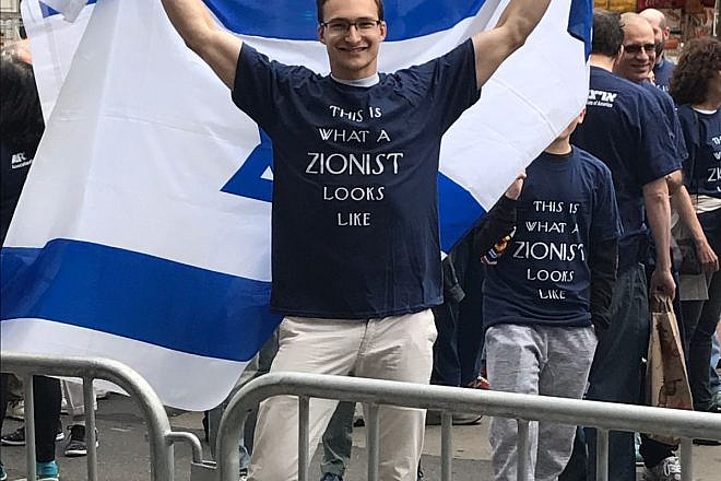 A young man proudly displaying the Israeli flag. Credit Shiryn Solny.