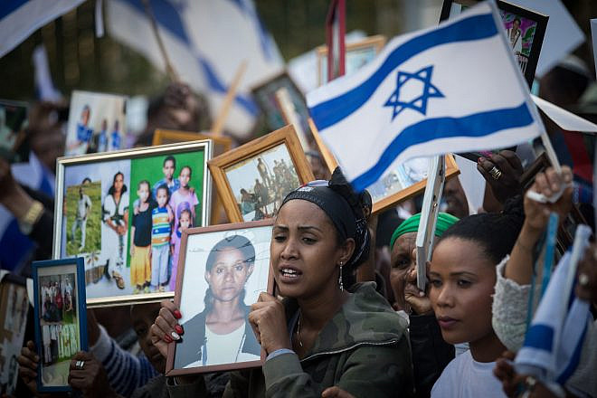 Israelis who immigrated from Ethiopia hold up family photos of loved ones who remain in Ethiopia during a protest to bring the rest of the Falash Mura in Jerusalem, on March 12, 2018. Credit: Yonatan Sindel/Flash90.