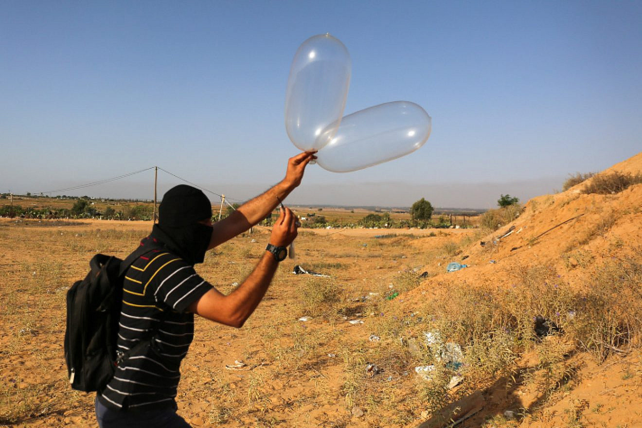 Palestinians in Gaza attach a balloon to flammable materials to be flown towards Israel. These incendiary devices have caused destruction to trees, animals, the land and the environment. June 17, 2018. Photo by Abed Rahim Khatib/Flash90.
