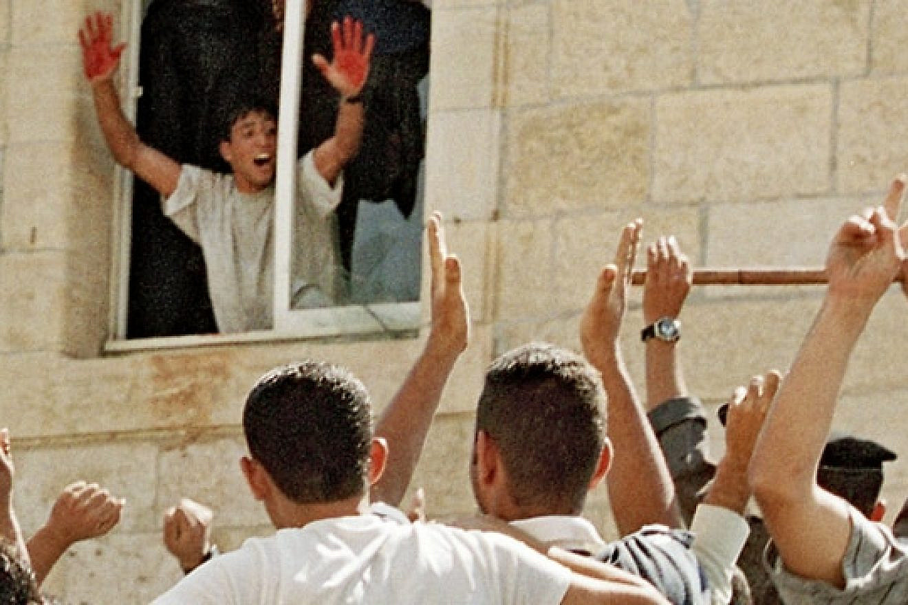 Aziz Salha, one of the participants in the infamous 2000 lynching in Ramallah of two IDF reservists, holds up his blood-stained hands. Salha was released in 2011 as part of the Gilad Shalit prisoner exchange deal. (PMW)