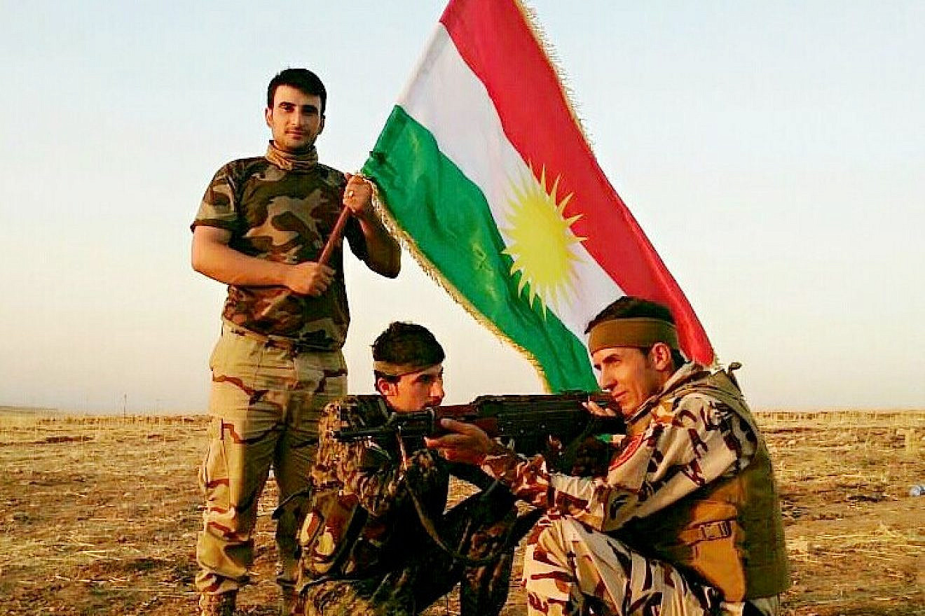 Kurdish Peshmerga fighters display their flag. Credit: Flickr.