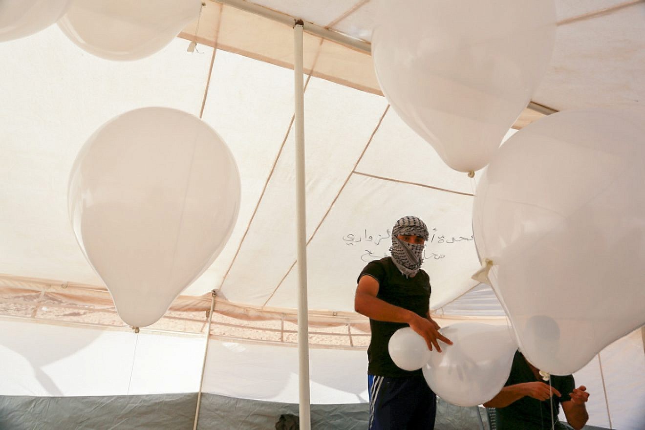 Palestinians prepare balloons that will be attached to flammable material during clashes with Israeli security forces on the Gaza-Israeli border on Aug. 10, 2018. Photo by Abed Rahim Khatib/Flash90.