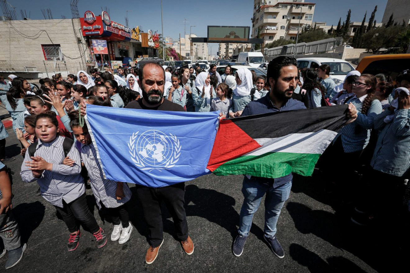 Palestinian protesters wave flags during a protest in Bethlehem against the U.S. decision to cut U.N. aid to Palestinians if the funds don’t stop going to support terrorists and their families, on Sept. 26, 2018. Photo by Wisam Hashlamoun/Flash90.
