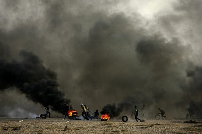 Palestinian demonstrators burn tires as part of a violent demonstration on the Gaza-Israel border that turned deadly on Oct. 12, 2018, when a Gaza exploded a bomb and infiltrated the security fence in the attempt to attack Israeli soldiers. Photo by Abed Rahim Khatib/Flash90.
