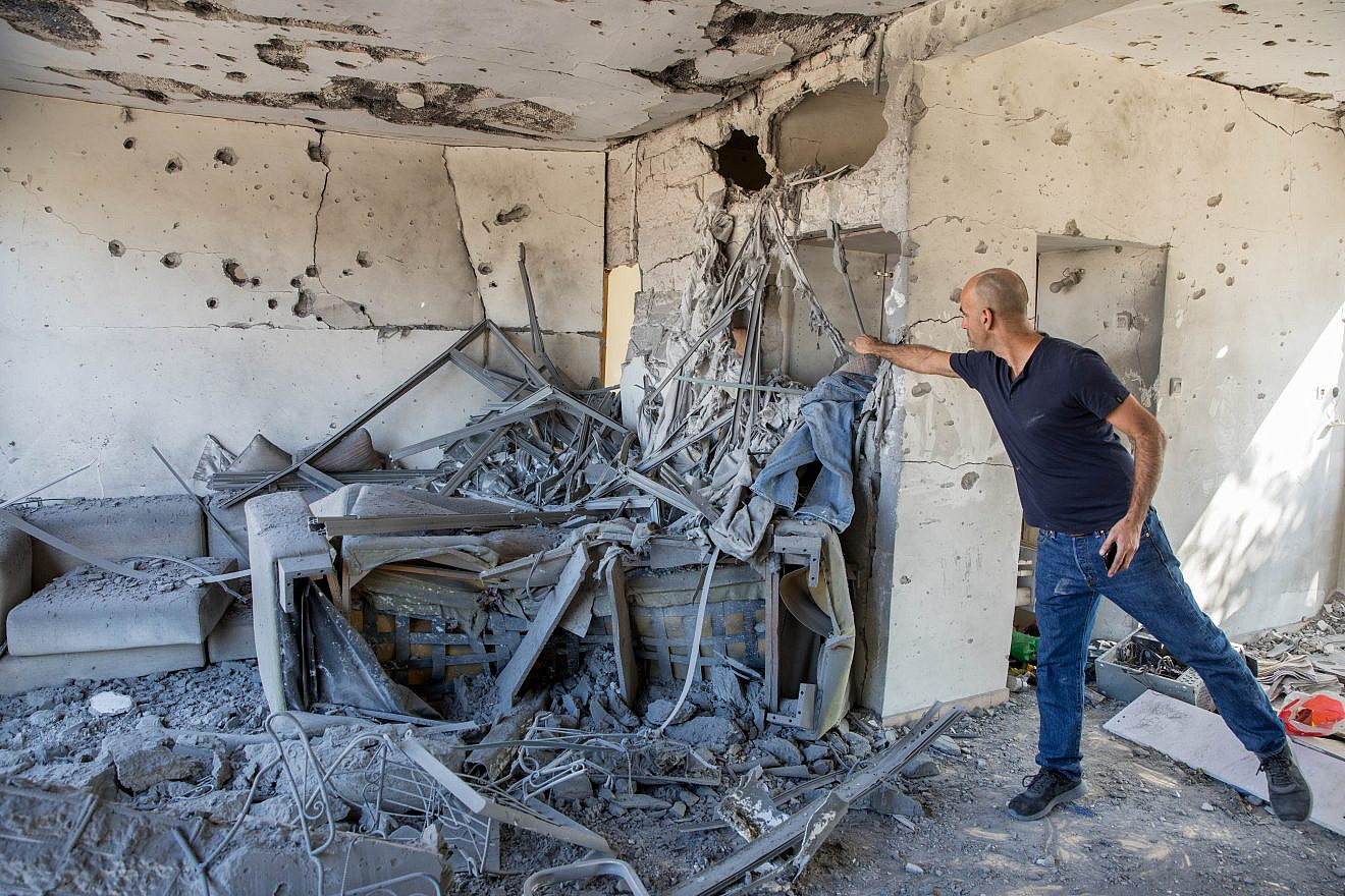 A man stands inside a house that was hit by a rocket fired from the Gaza Strip in the southern Israeli city of Ashkelon on Nov. 13, 2018. Photo by Nati Shohat/Flash90.