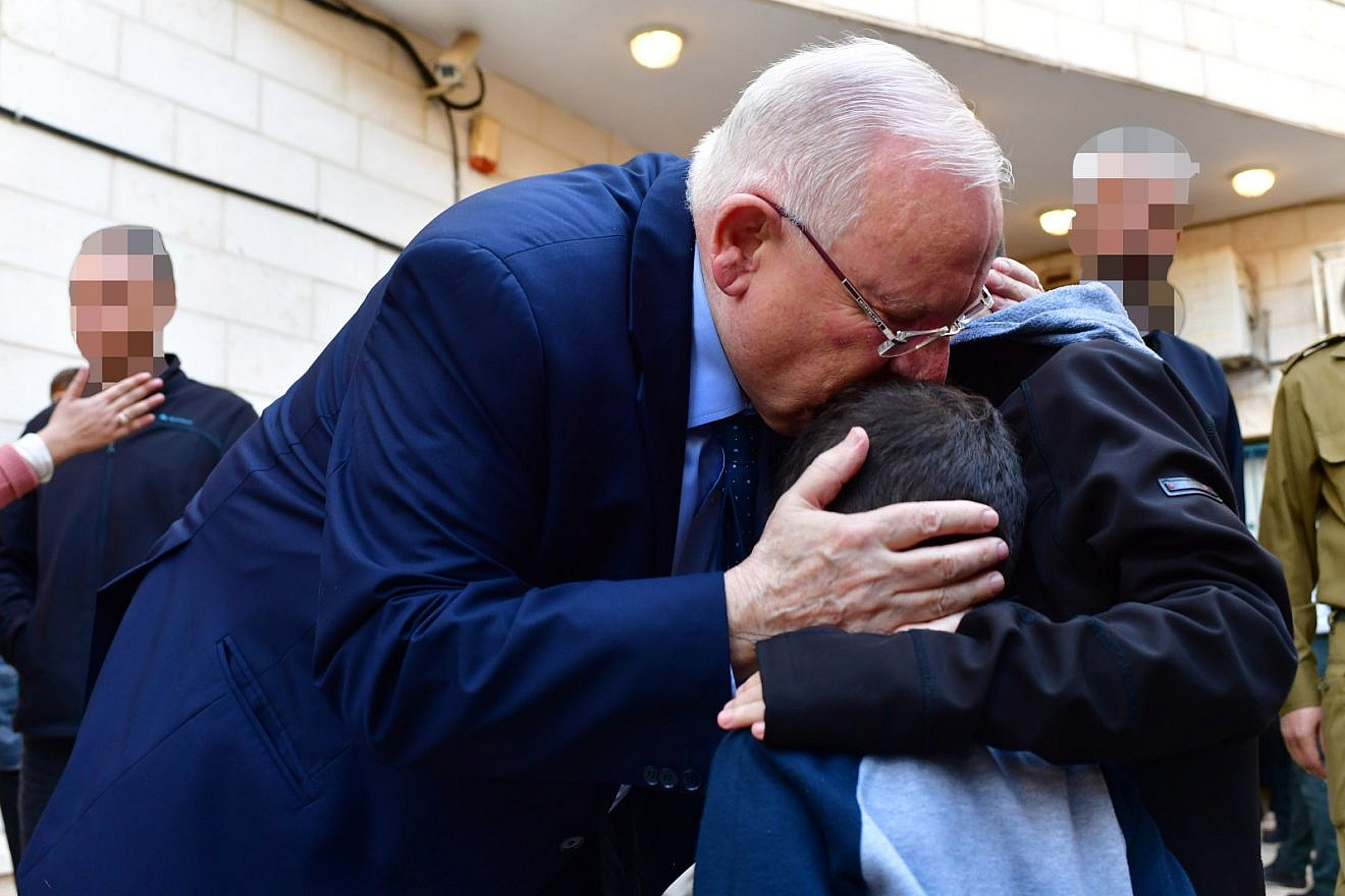 Israeli President Reuven Rivlin hugging the children of Lt. Col. M. at their father's funeral, telling the children “your dad was a hero, the greatest hero.” Credit: Kobi Gideon/GPO.